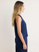 Navy blue Stevie Tank on model in profile. Sleeveless, relaxed fit, smooth fabric.