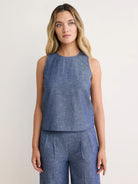 Chambray blue sleeveless tank top with a round neck. Visible woven chambray texture.