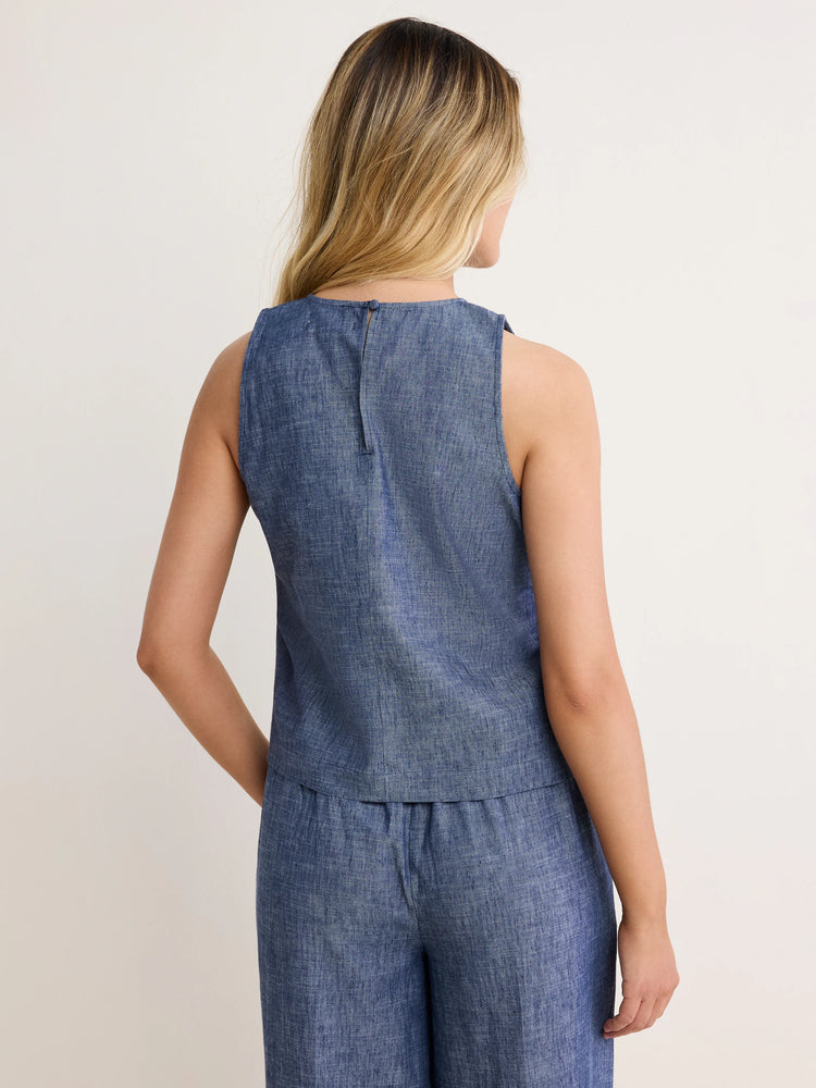 Back view: Blue chambray sleeveless tank with a round neck, keyhole & button closure, and visible slub texture.