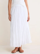 White, flowy crinkled skirt with an elastic waist, shown ankle-length on a model.