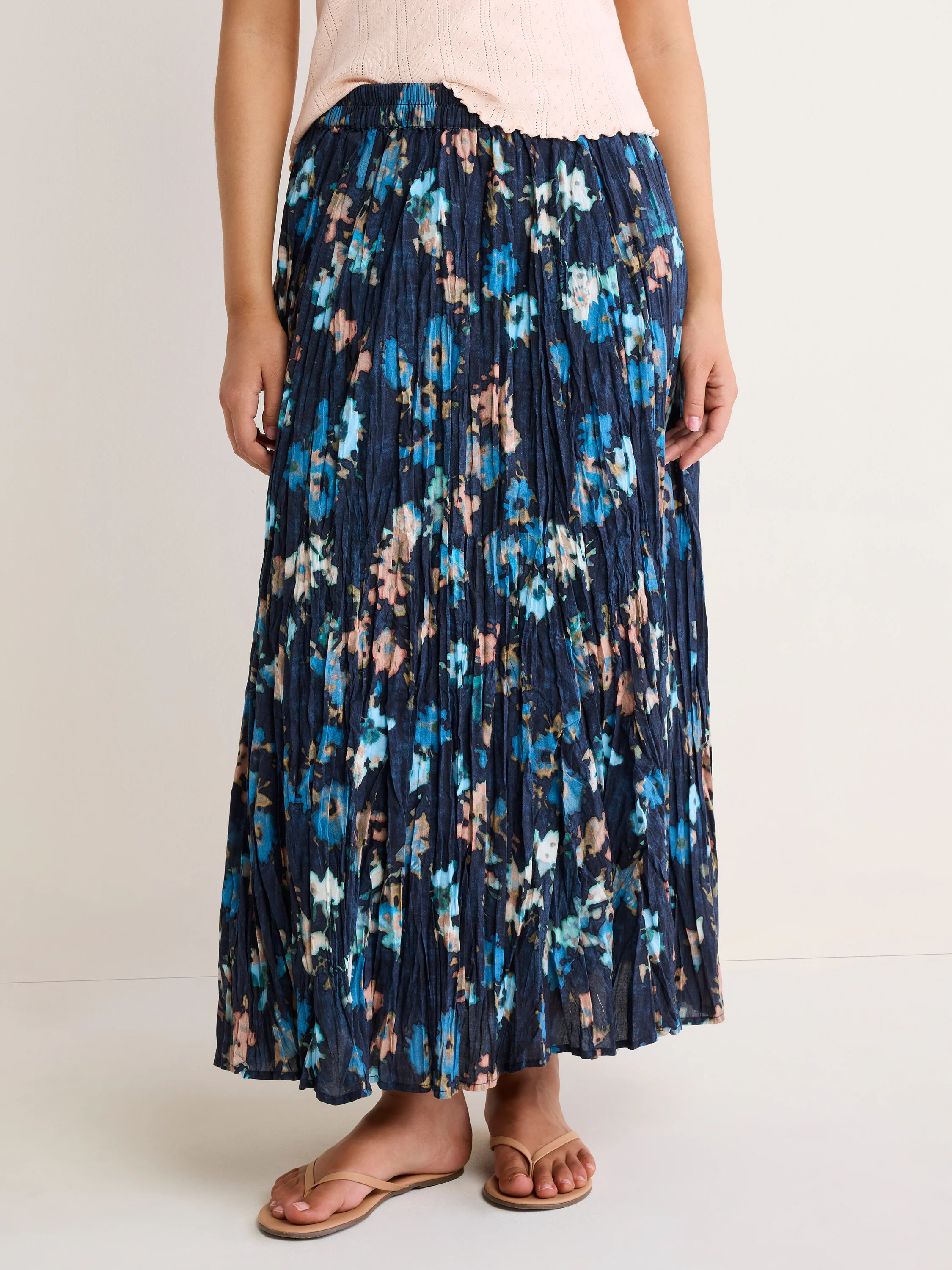 Navy crinkle maxi skirt with abstract florals in light blue, teal, peach, and white.