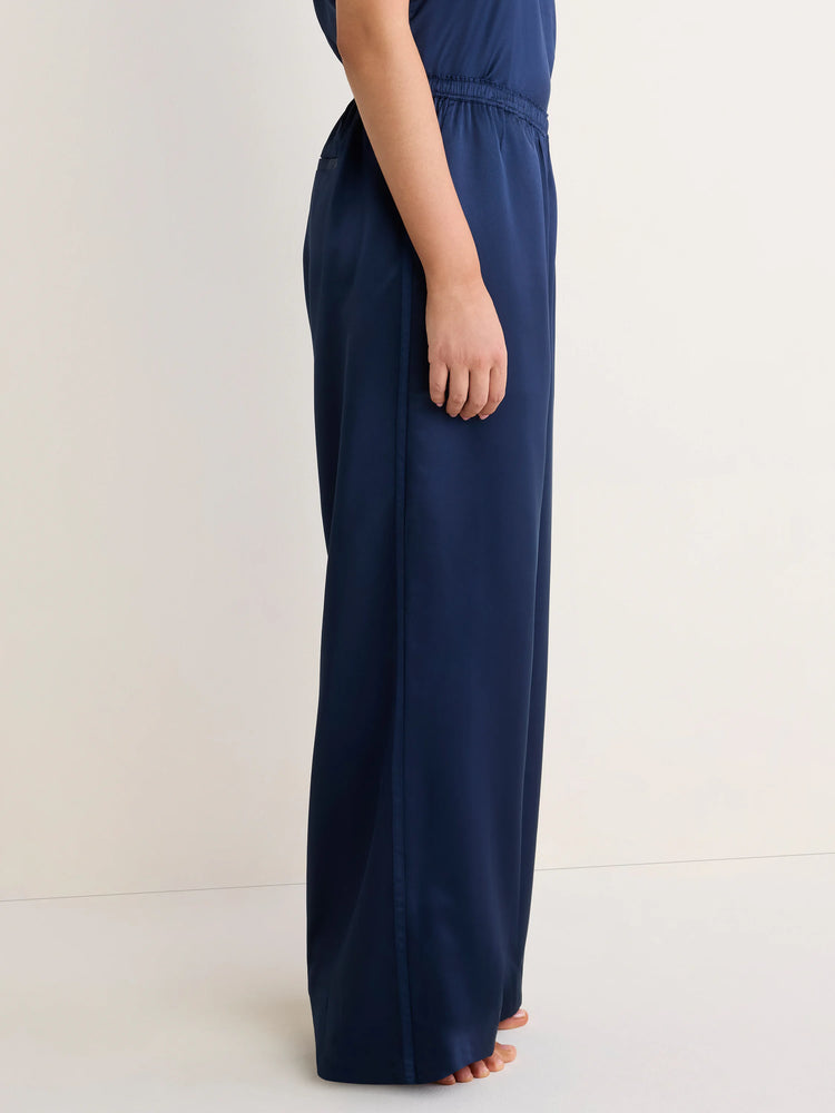 Dark navy wide-leg satin pants with an elastic waist and a vertical grosgrain ribbon trim down the side.