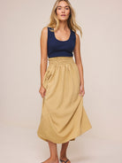 Dress with navy ribbed sleeveless top and flowing, crinkled khaki midi skirt, featuring a shirred waist.