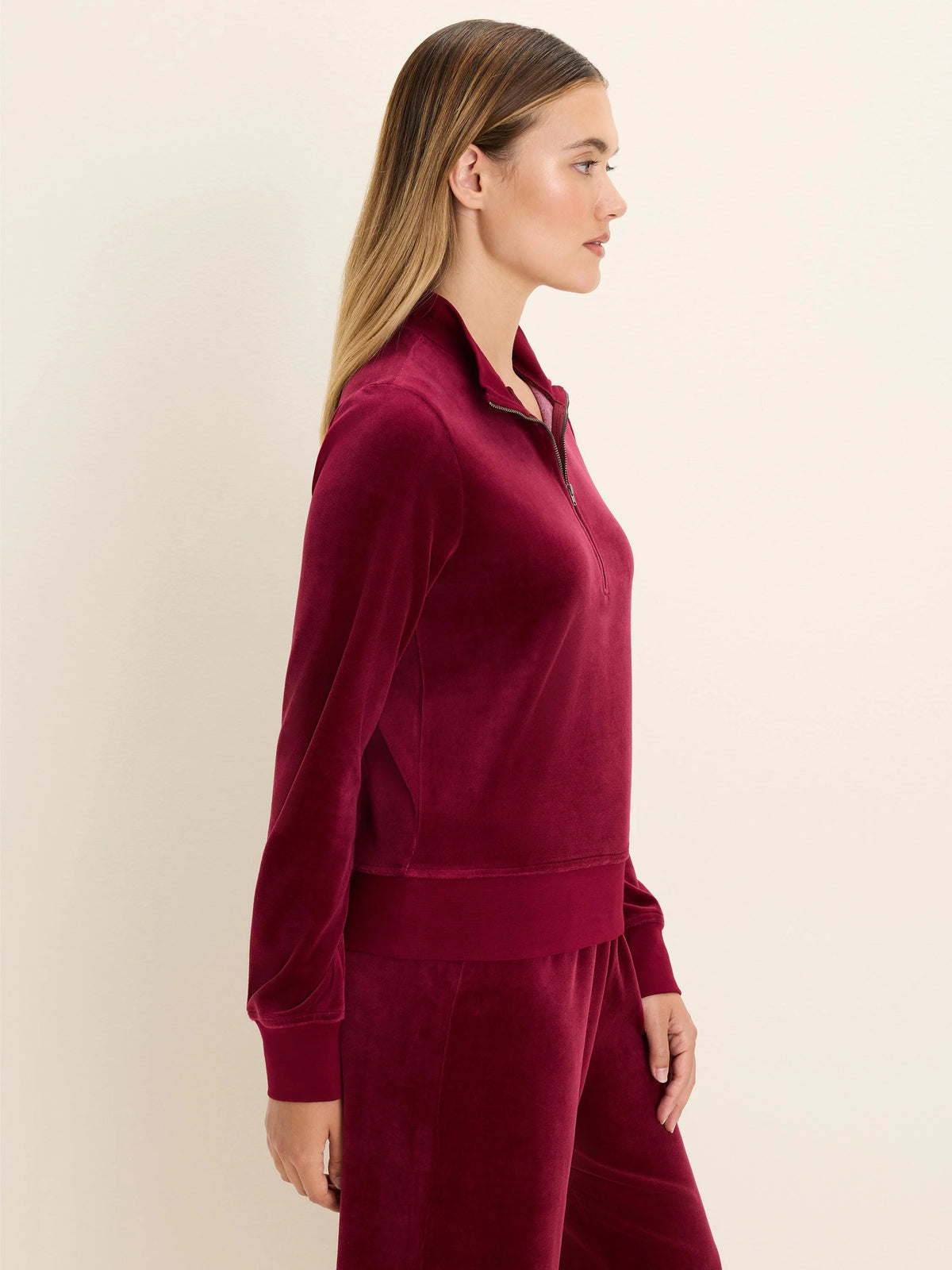 Burgundy velour half-zip pullover with a high stand collar, exposed silver zipper, and plush texture.