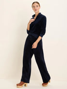 Navy velour half-zip pullover with stand collar, ribbed cuffs, and matching wide-leg drawstring pants.