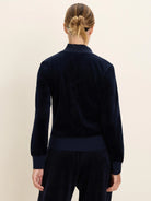 Navy velour half-zip pullover with ribbed cuffs and hem, worn by a woman from the back, with matching pants.