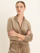Tan velour half-zip pullover with a stand-up collar, silver zipper, and ribbed cuffs. Soft, plush texture.