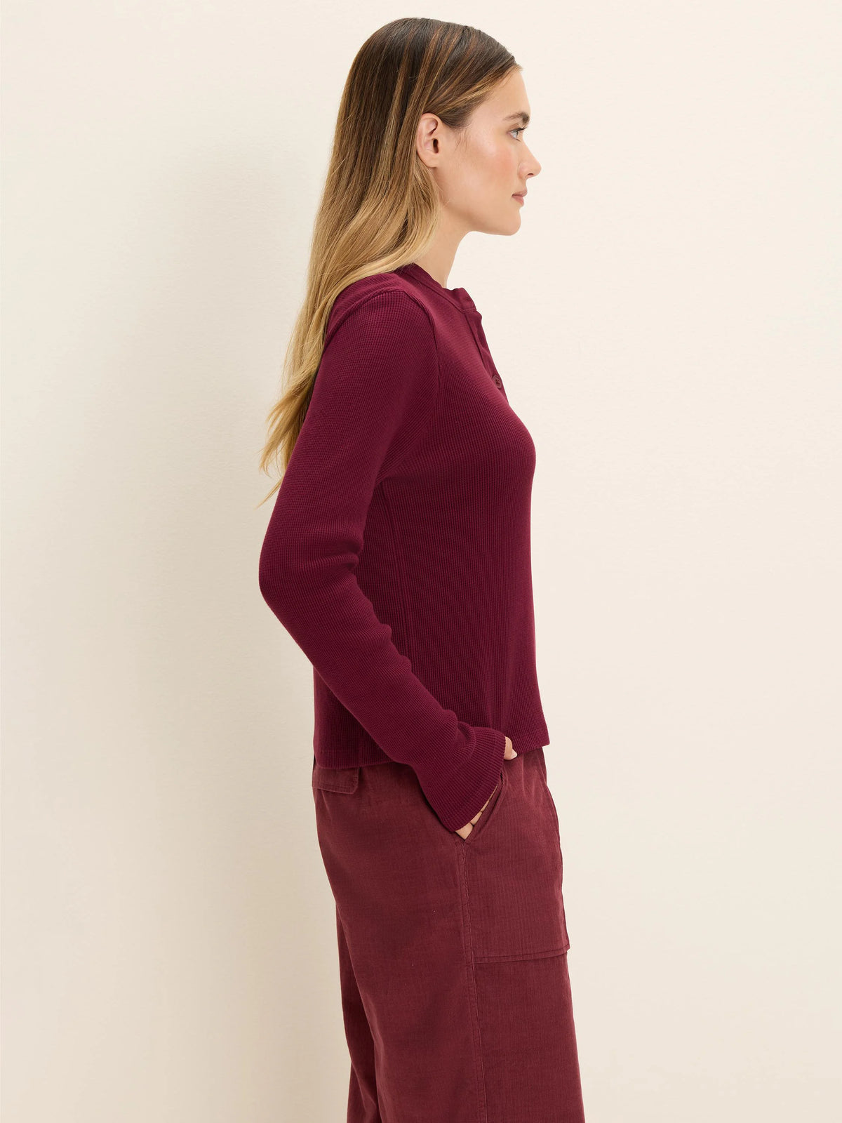 Deep red thermal waffle knit Henley top with long sleeves and a button placket.