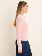 Light pink long-sleeve Henley top with waffle knit texture and button placket, modeled on a woman.