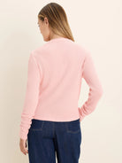 Light pink long-sleeved top with waffle knit texture, modeled from the back.
