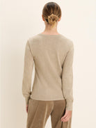 Back of model wearing a heather beige scoop neck sweater with long sleeves, ribbed cuffs, and hem.