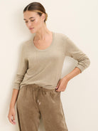 Light beige fine-knit scoop neck sweater with long sleeves and ribbed trim.