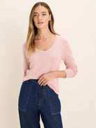 Light pink scoop neck sweater with a wide, rounded neckline and long sleeves. Subtle knit texture.
