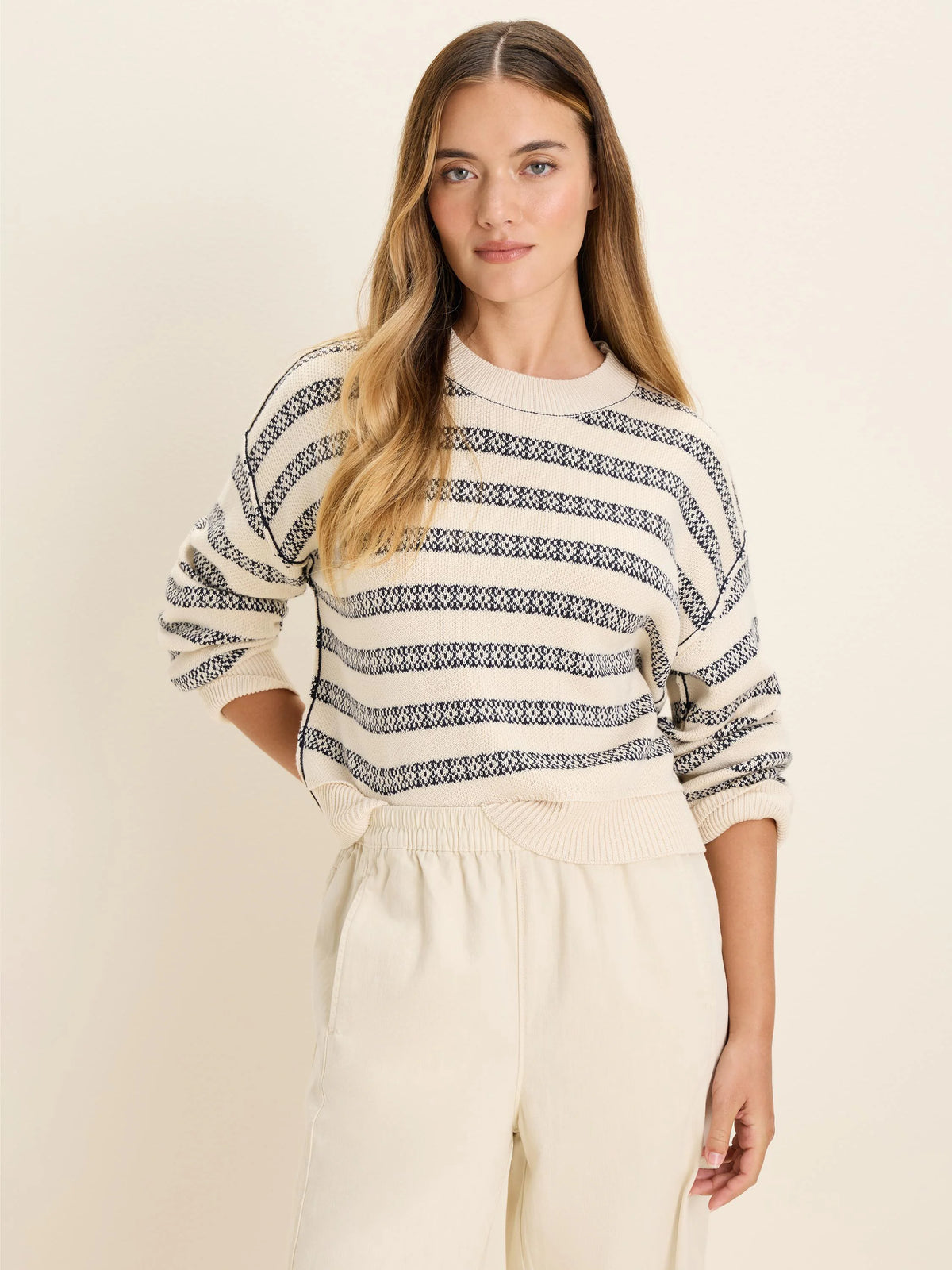 Off-white cotton jacquard sweater with navy geometric horizontal stripes, crew neck, and relaxed fit.