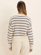 Off-white jacquard sweater with dark blue patterned horizontal stripes. Ribbed cuffs and hem.