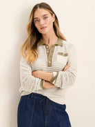 Cream mesh knit polo sweater with olive collar, button placket, striped cuffs, and chest pocket.