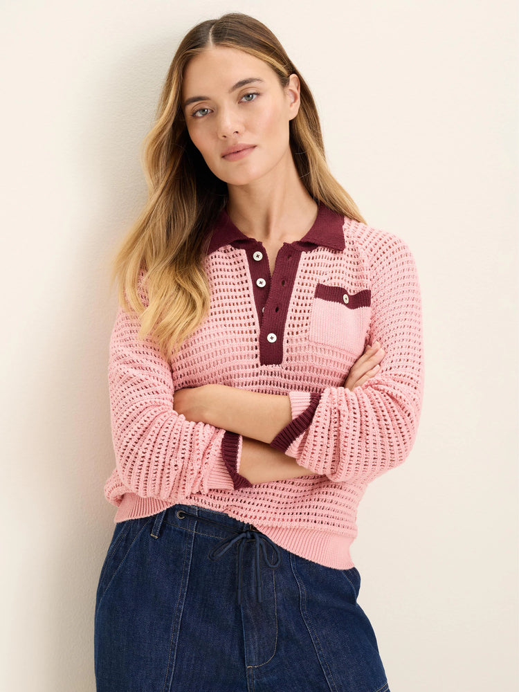 Pink mesh long-sleeve polo sweater with burgundy collar, button placket, and pocket trim. Features open knit texture.