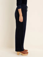 Navy blue velour pants with an elastic drawstring waist and straight legs, shown from the side.