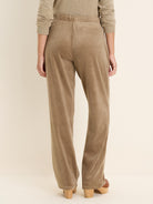 Taupe velour pants with elasticated waist and straight leg. Back view.