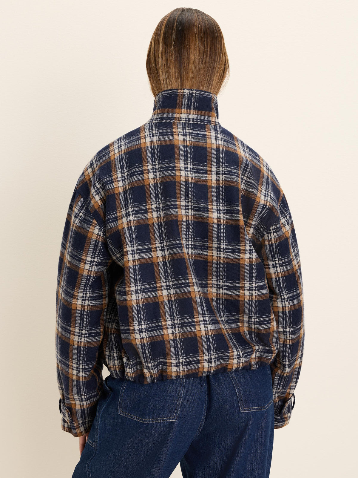Navy plaid jacket with tan & off-white lines, high collar, elastic hem, seen from back.