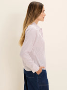 Off-white striped shirt with thin vertical pink and dark gray stripes. Long-sleeved, collared.