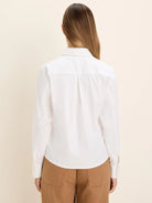 Back view of a white long-sleeve shirt. Features collar, shoulder yoke, and center back pleat.