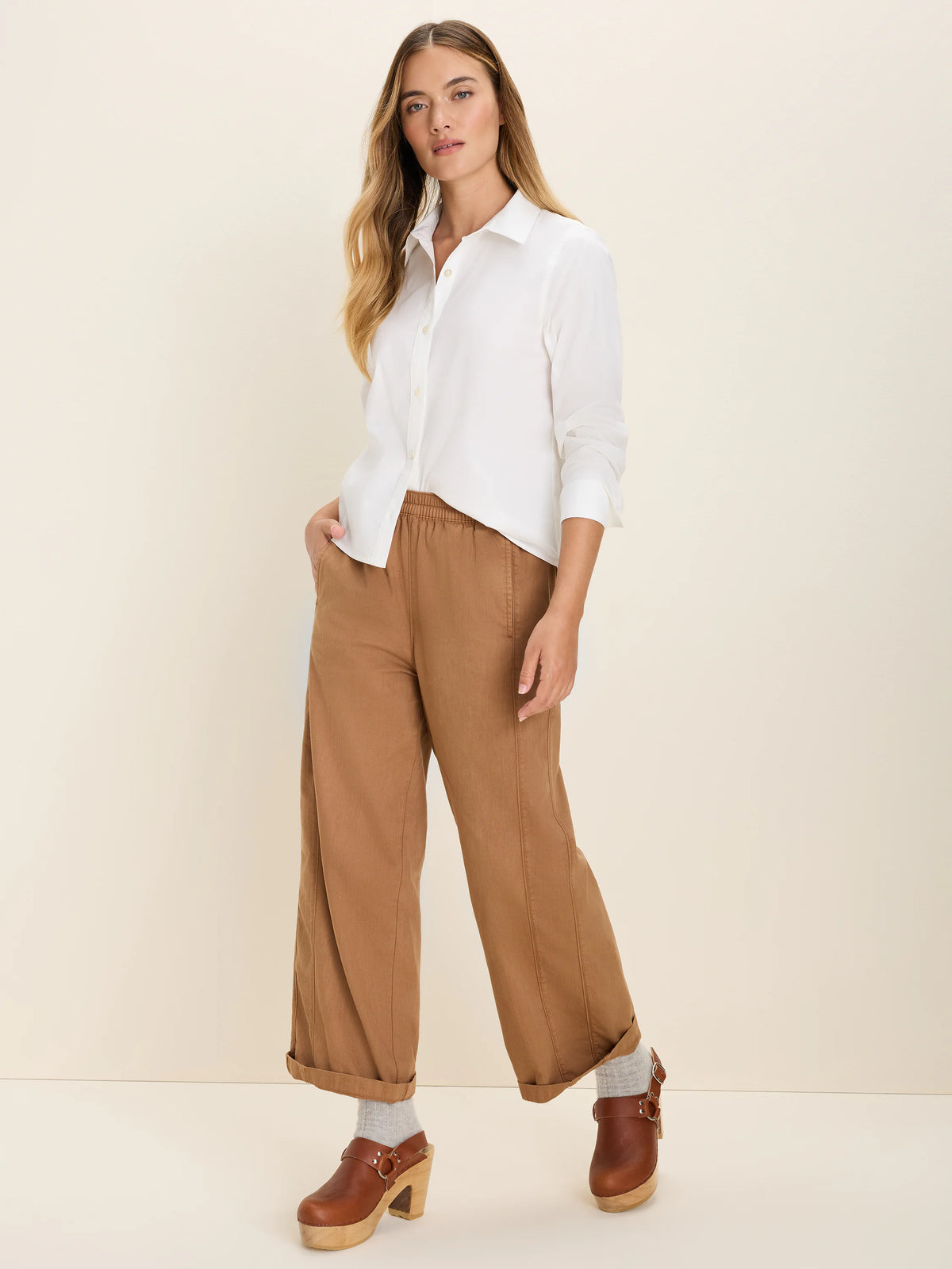 Earthy brown wide-leg ankle pants with elastic waist, cuffed hems, and visible vertical leg seams.