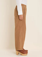 Tan wide-leg ankle pant with elastic waist, side pockets, and front seam details, shown from the side.