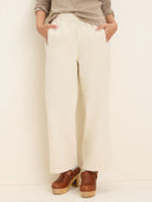 Off-white wide-leg ankle pants with an elasticized waist and side pockets.