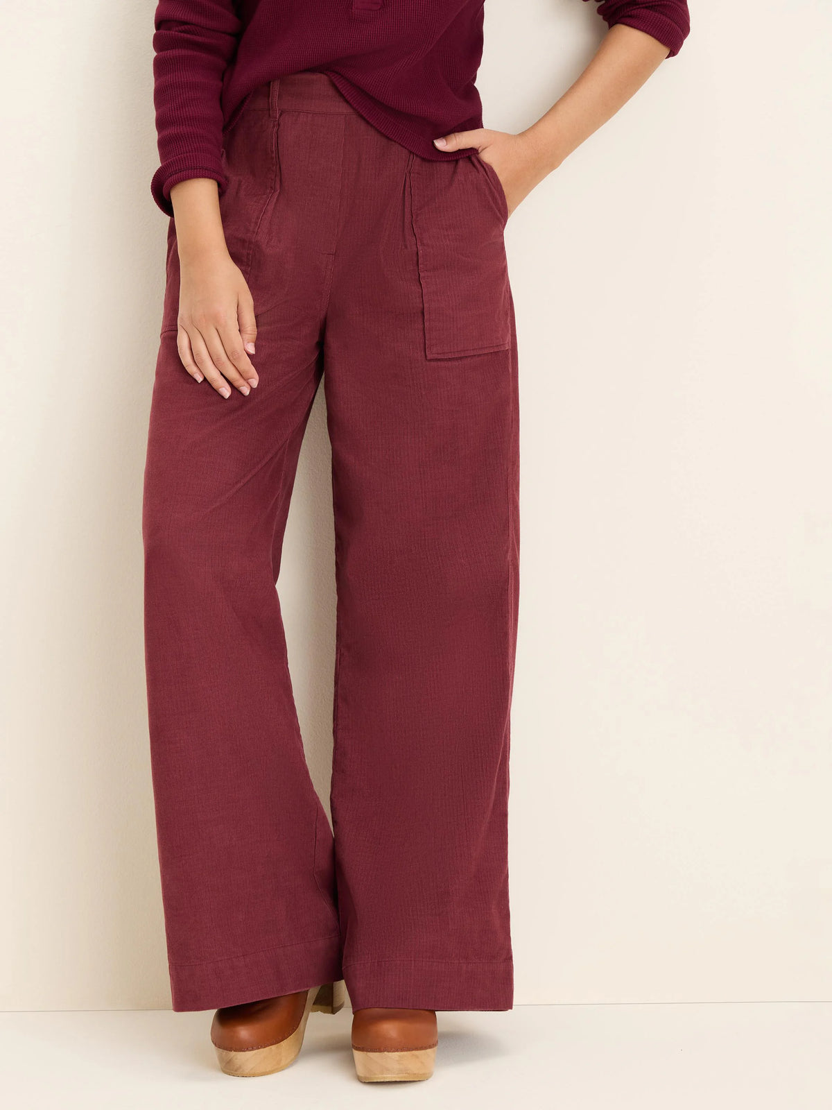Dark red, wide-leg baby corduroy pants with fine vertical texture and large front patch pockets.