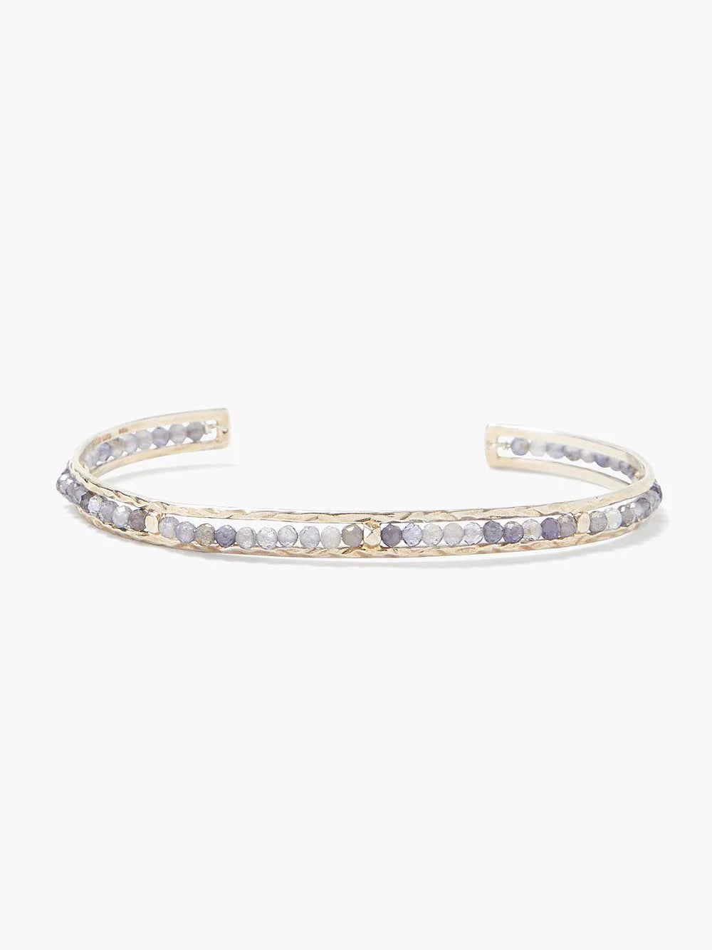 Gold cuff bracelet with row of small, light purple and gray stones.
