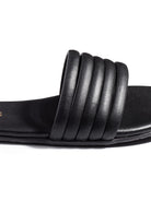 Black slide sandal with five parallel textured straps across the footbed.  Flat sole.