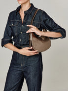 Small metallic bronze, smooth curved shoulder bag with a matching strap.