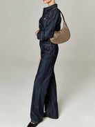 Small, metallic bronze crescent shoulder bag with thin strap.