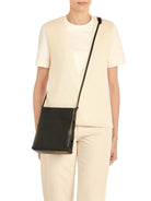 Black leather cross-body bag with a thin black strap threaded through two loops on each side.