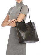 Black leather tote bag with two top handles.  A subtle texture is visible on the bag.