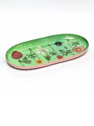 Oval tray. Light green interior with multi-colored botanical floral print. Pale pink exterior.