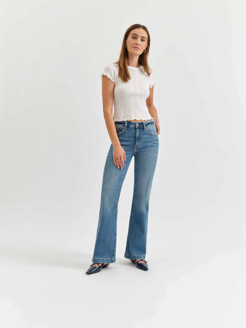 Medium blue mid-rise flare jeans worn by a model.