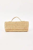 Natural tan woven straw clutch with a short top handle and front flap.
