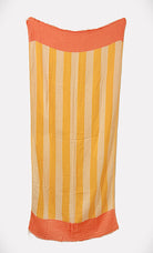 Vertical striped towel with mustard yellow and beige stripes, and textured coral-orange bands at top and bottom.