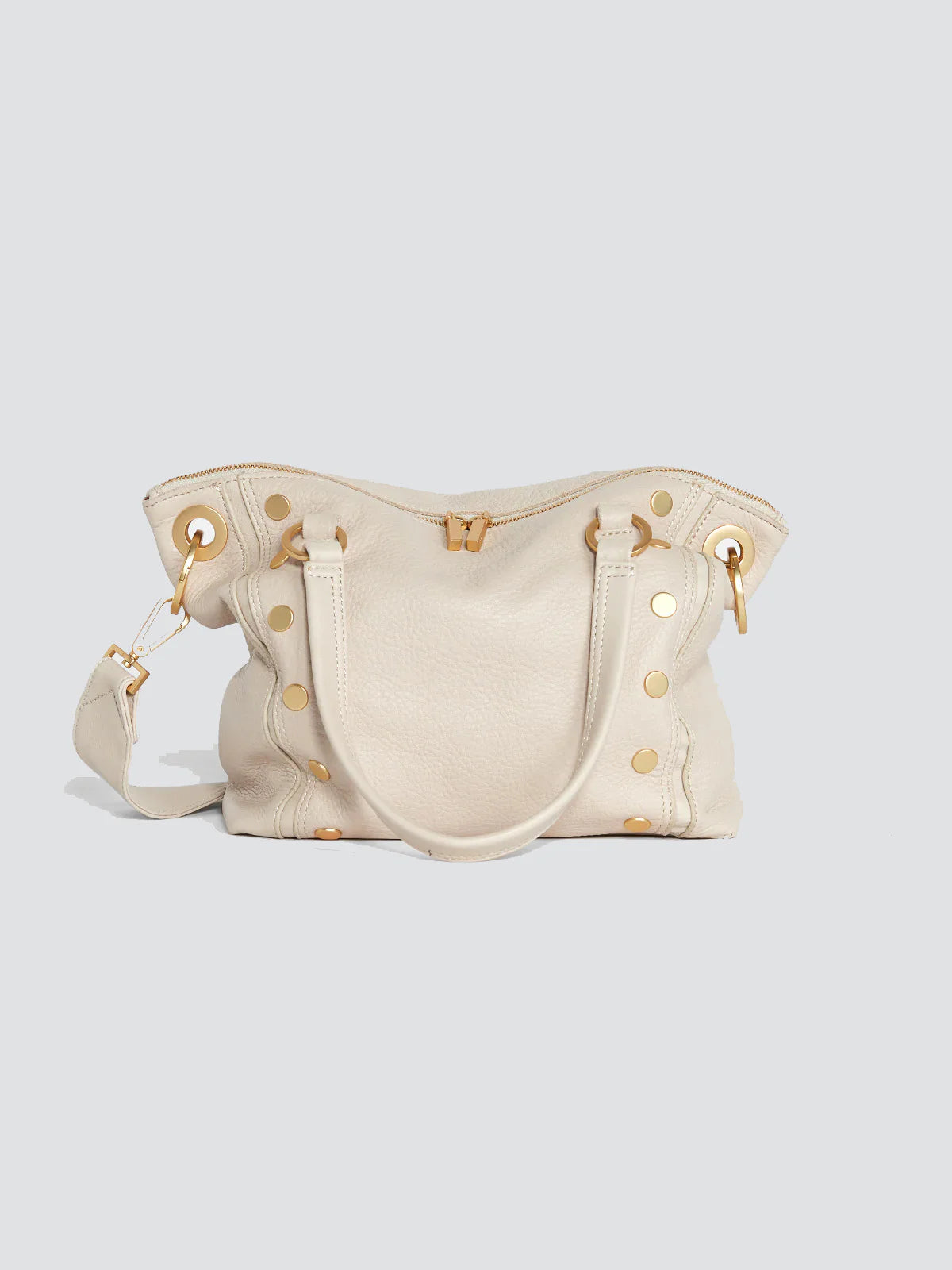 Cream pebbled leather satchel with gold hardware, top handles, shoulder strap, and decorative side rivets.