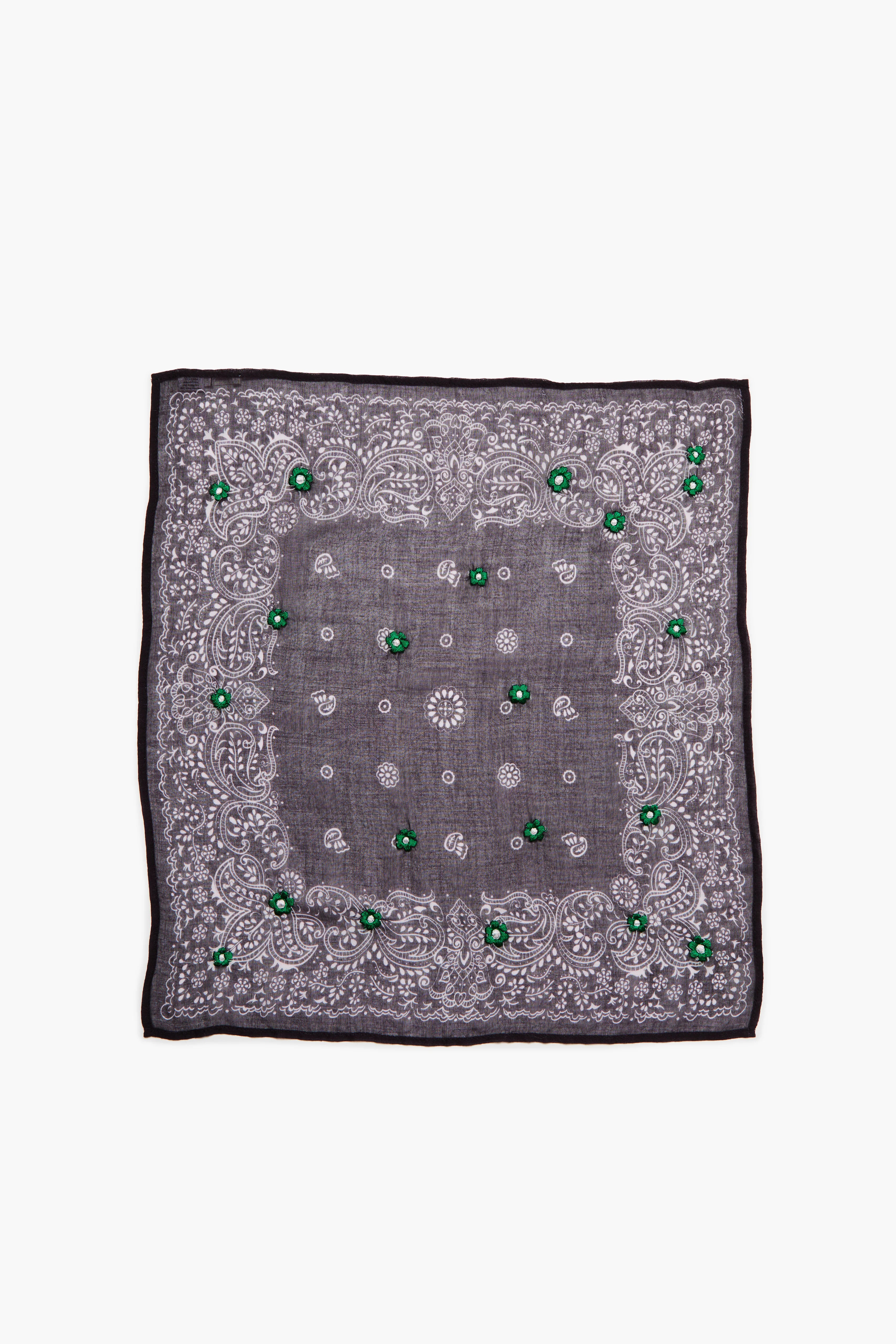 Dark grey bandana with white paisley patterns, scattered bright green embroidered flowers, and a black border.
