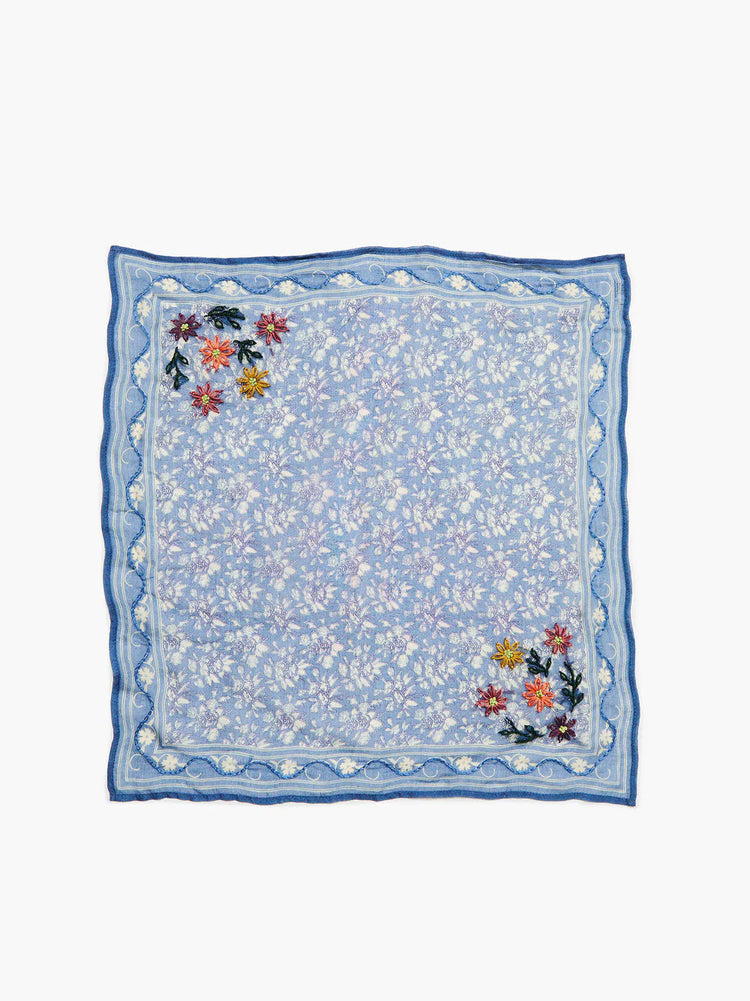 Square light blue bandana with white floral print, a dark blue scalloped edge, and colorful embroidered flowers in...