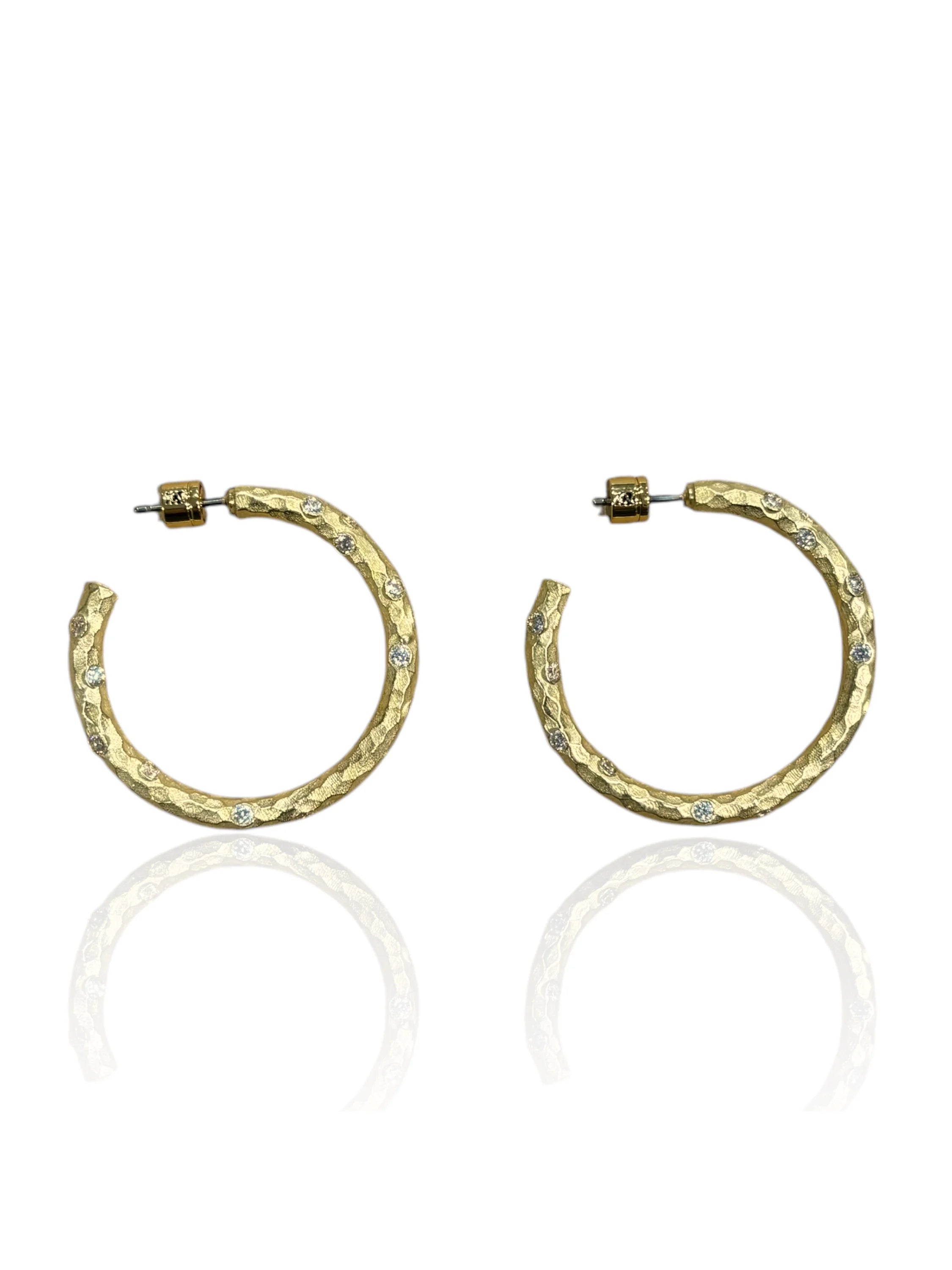 A pair of gold hammered hoop earrings with embedded clear stones and post backs.