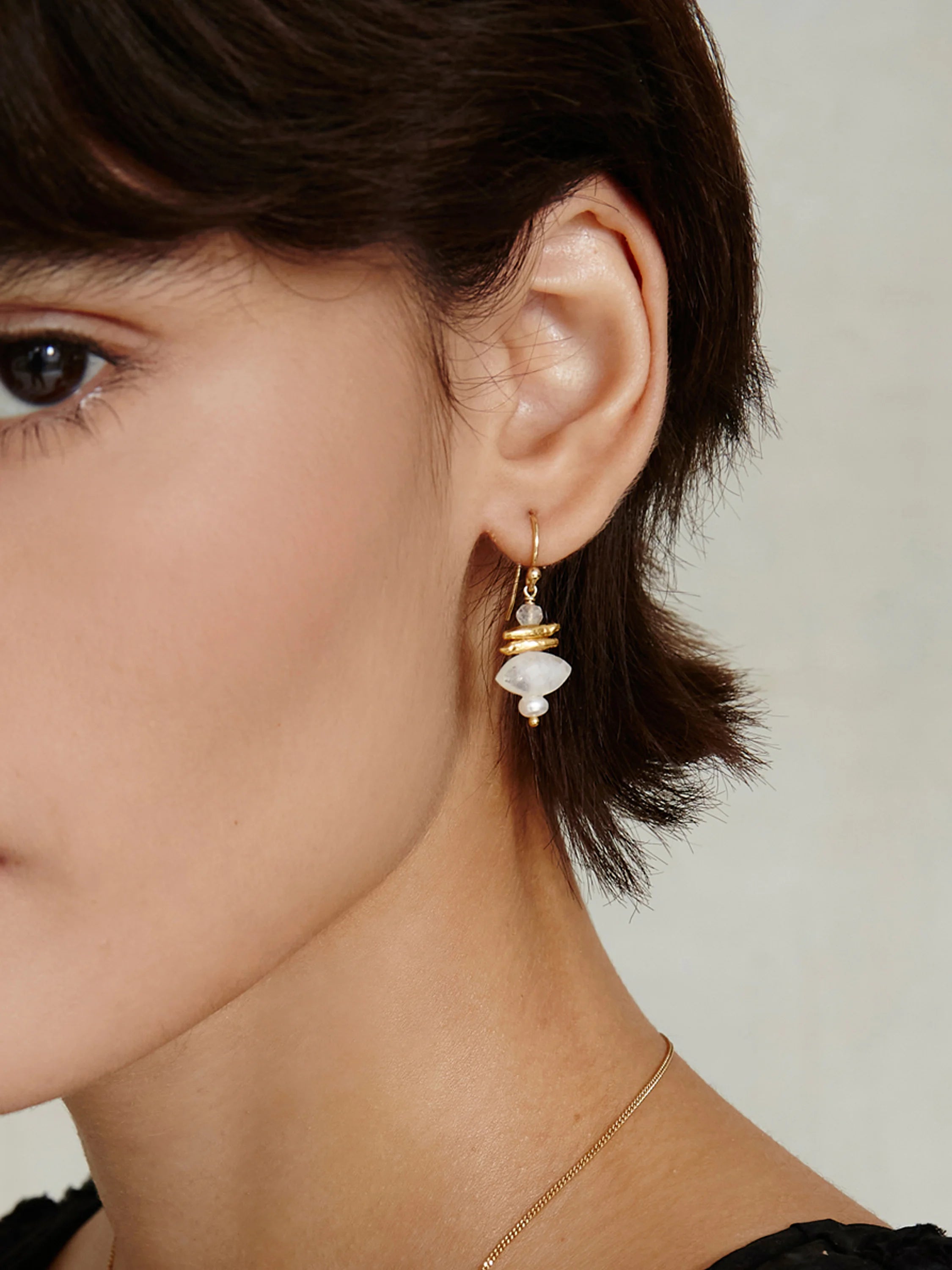 Gold dangle earrings with stacked milky white moonstone, textured gold accents, and a small white pearl.