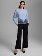 Light blue sweater with black vertical flame stitch pattern along the bottom hem.