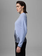 Light blue sweater with a black flame stitch pattern around the hem.