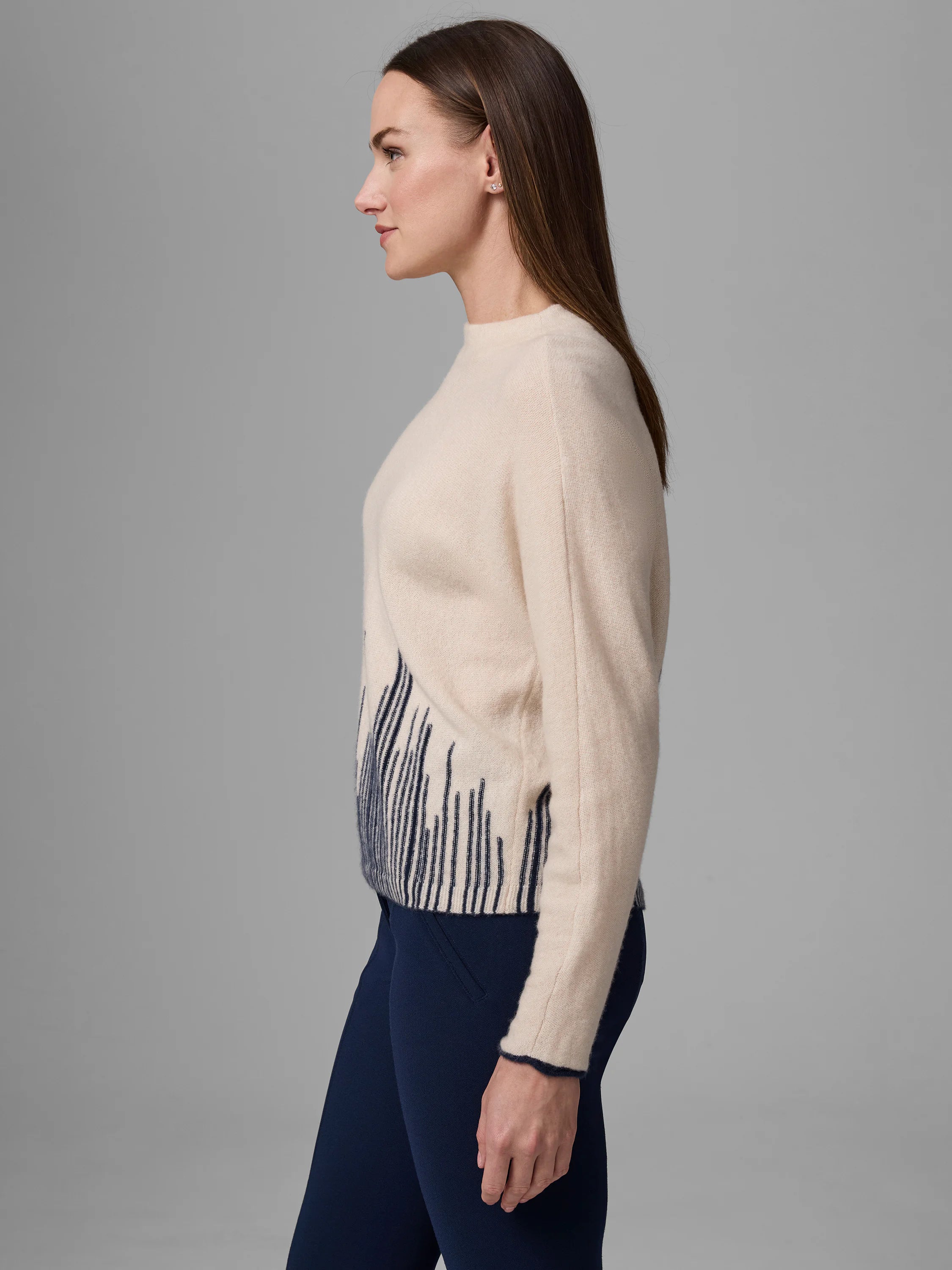 Cream sweater with navy blue flame stitch pattern on lower front. Navy trim on cuffs and hem.