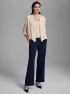 Pale cream knit cardigan with an open, draped front and long sleeves.