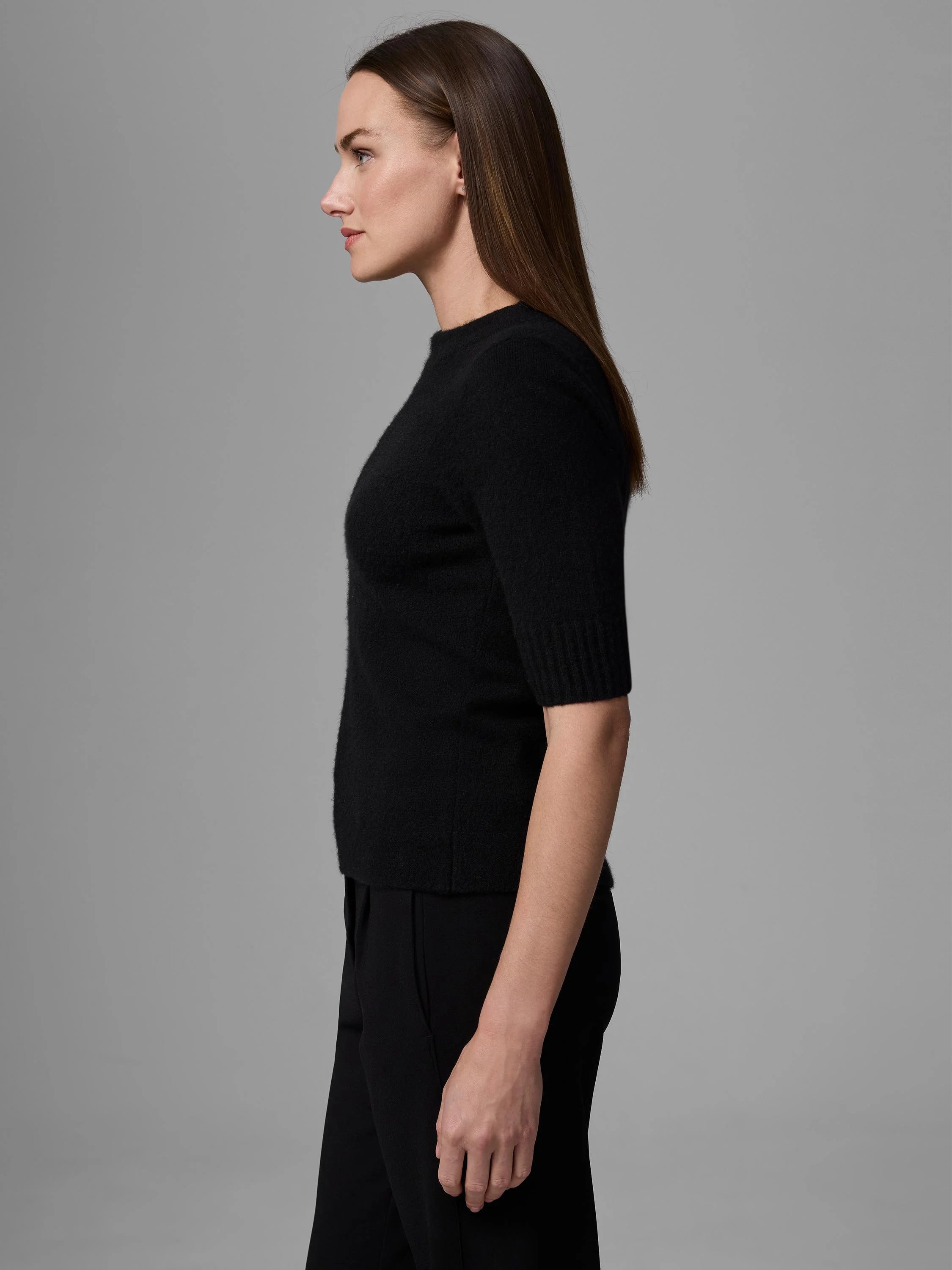 Model's side view: black mock neck short-sleeve sweater with soft, fuzzy texture.